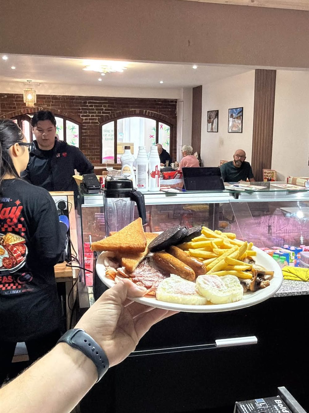 A breakfast plate being handed over the counter